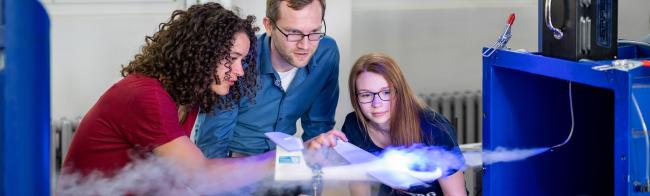 Zwei Studentinnen und ein Professor beobachten den Strömungskanal