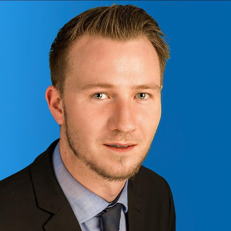 Portraitfoto eines Mannes im Anzug vor marineblauem Hintergrund